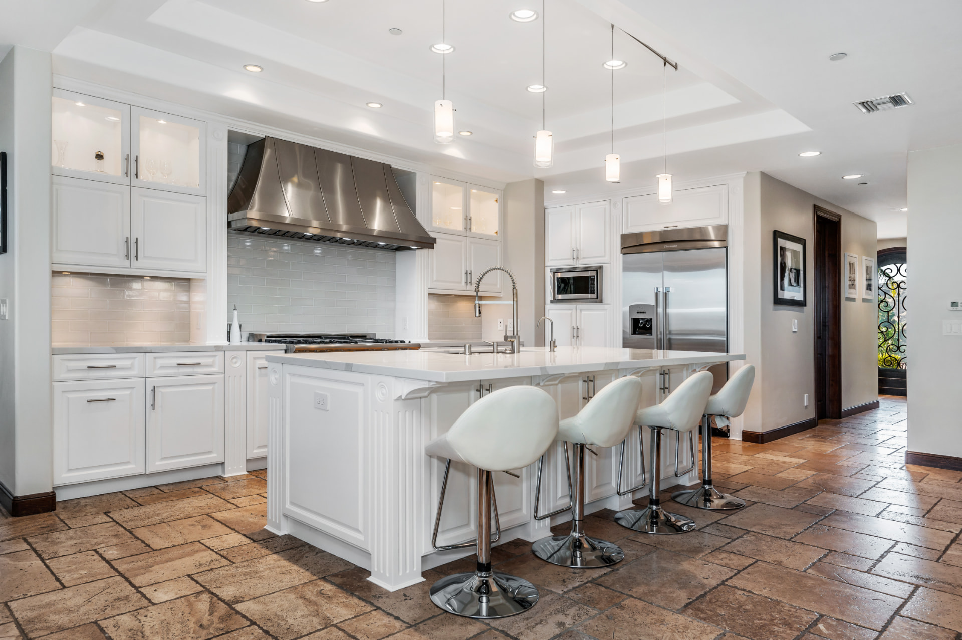 Custom kitchen remodel with white cabinetry, island seating, and pendant lighting in Southwest Florida