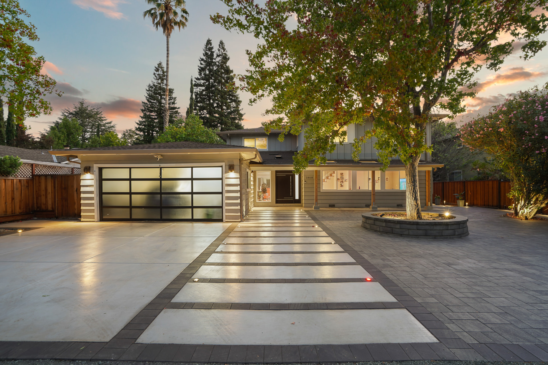 Custom-built luxury home exterior with modern glass entry and paver driveway, Southwest Florida